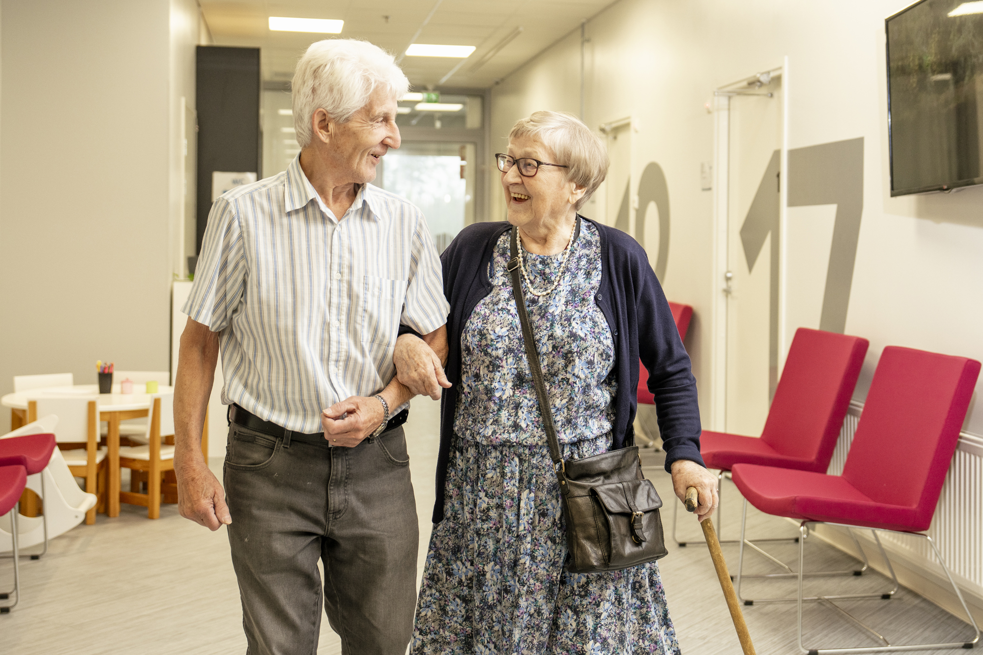 Kuvassa kaksi senioria kävelee Pk Terveyden vastaanottotiloissa. Geriatrian eli ikäihmisen vastaanotolla edetään tarvittessa rauhallisempaan tahtiin ja selvitetään useampi mieltä painava oire tai asia läpi.
